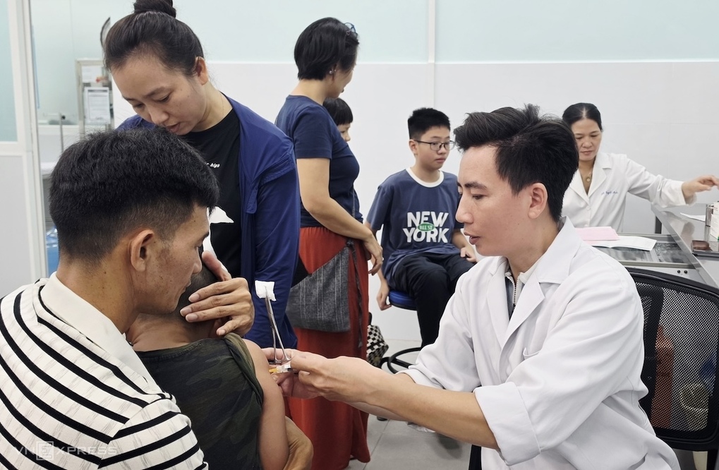 Vợ chồng chị Trúc đưa con trai đi tiêm vaccine não mô cầu sáng 17/10 tại Viện Pasteur TP HCM. Ảnh: Lê Phương
