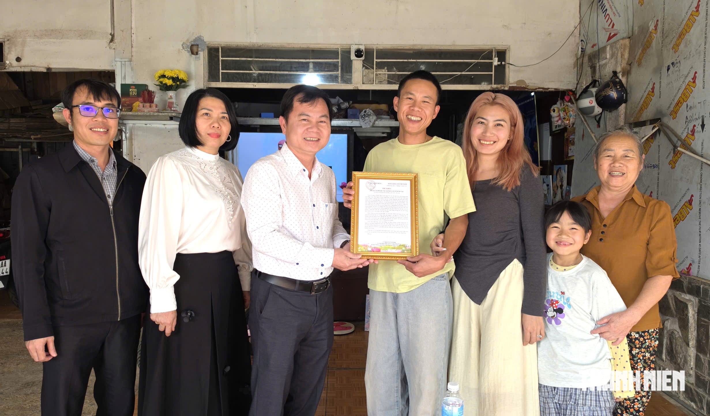 Vợ chồng anh Trần Văn Định (thứ 3 và 4 từ phải qua) vui mừng nhận thư khen của Bí thư Tỉnh ủy Lâm Đồng