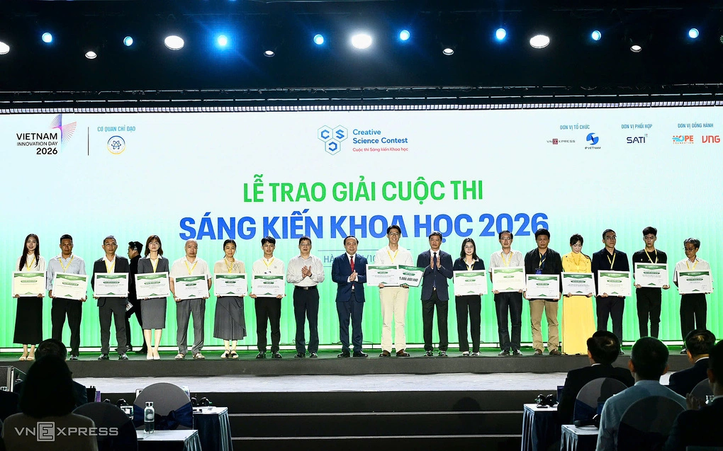 Bộ trưởng Khoa học và Công nghệ Vũ Hải Quân, ông Phạm Hiếu, Tổng biên tập báo VnExpress và ông Lưu Hoàng Long, Cục trưởng Sở hữu trí tuệ và các tác giả được giải Cuộc thi Sáng kiến Khoa học 2026. Ảnh: Giang Huy