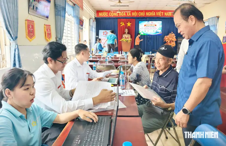 Ông Phan Công Khanh, Chủ tịch UBND phường Phú Lợi (trái) đến điểm phục vụ dịch vụ công lưu động thăm hỏi người dân