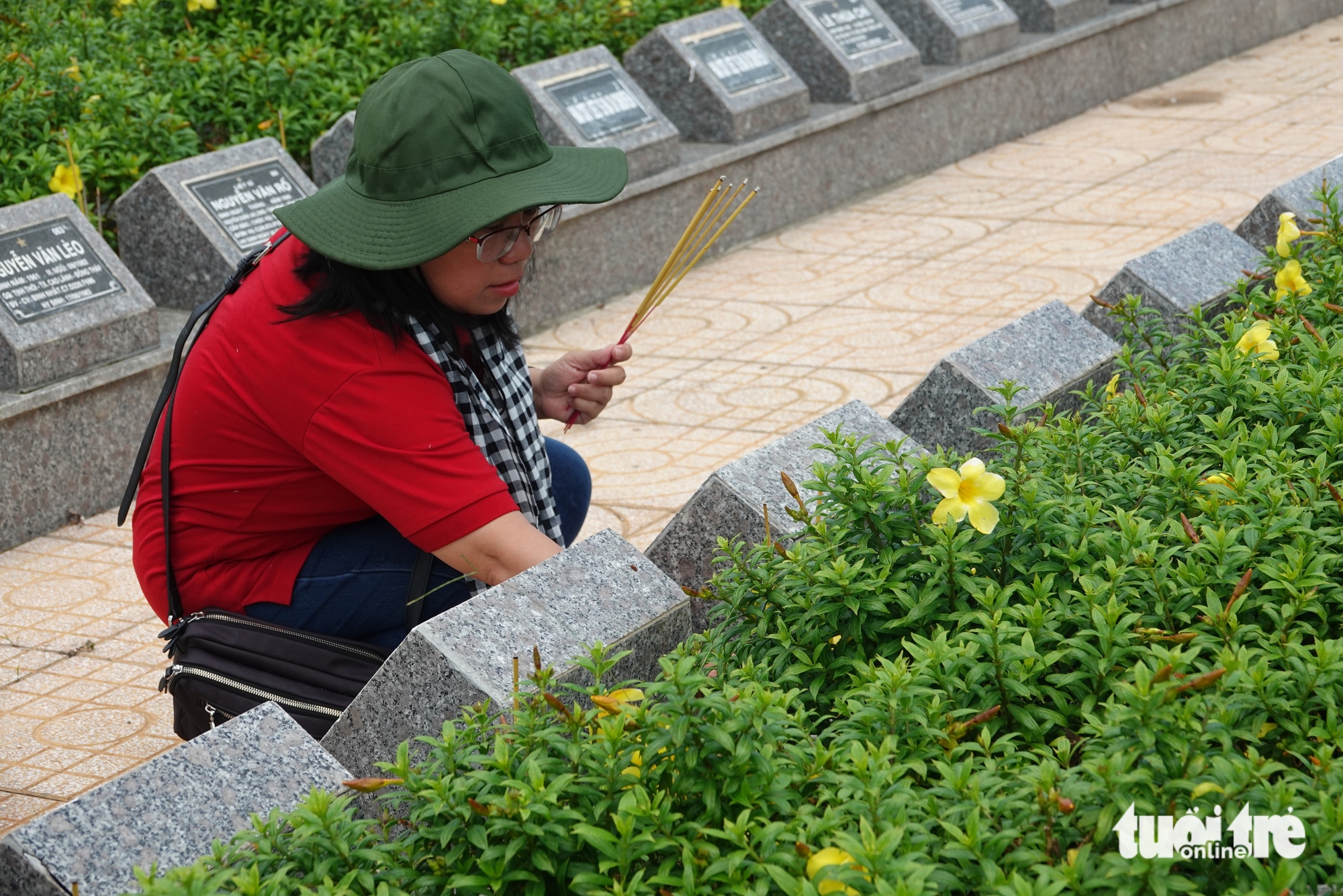 Phó trưởng Ban Tuyên giáo và Dân vận Thành ủy TP.HCM Đinh Thị Thanh Thủy thắp nhang tại Nghĩa trang liệt sĩ Tam Nông - Ảnh: LINH ĐOAN